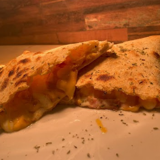 Calzone Media Luna, salsa de tomate, mozzarella, bacon, queso cheddar