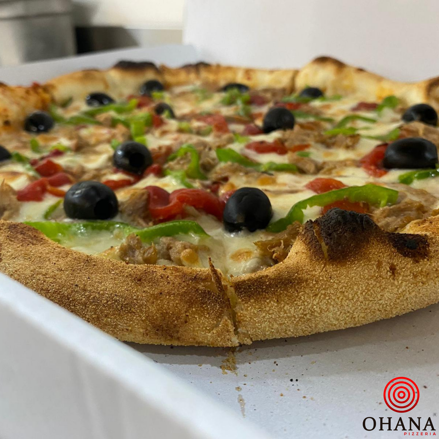 Huertana, salsa de tomate, mozzarella, pimiento verde, pimiento rojo asado, aceitunas negras, atún